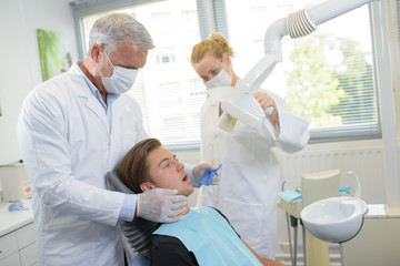 Dentist taking impressions of young man's teeth