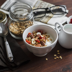 Healthy Breakfast - Greek yogurt and homemade granola on a dark wooden surface. Healthy food