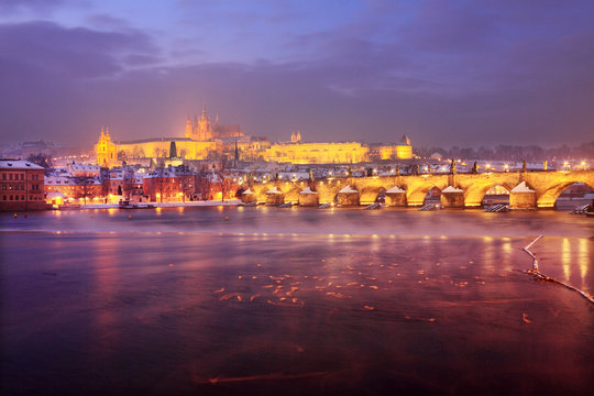Night snovy christmas Prague gothic Castle and St. Nicholas' Cathedral with Charles Bridge, Czech republic