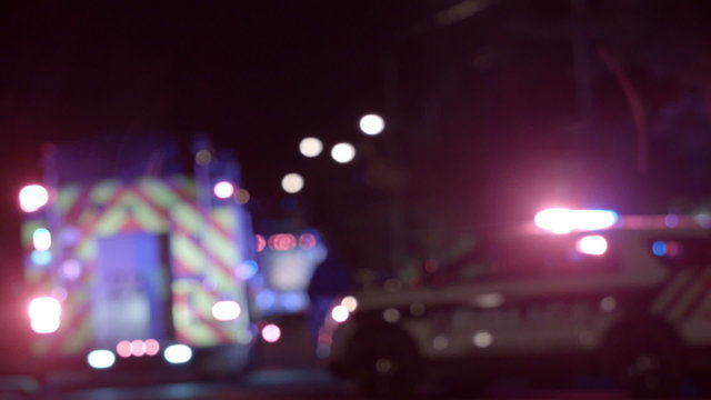 Ambulance, Cops and Firetrucks Blurry Lights Background at Night during a House Fire