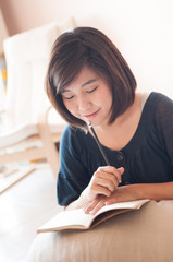 Young asian woman writing.