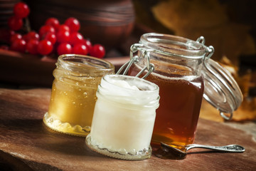 Honey assortment in small jars in the autumn background with row