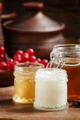 Honey assortment in small jars in the autumn background with row