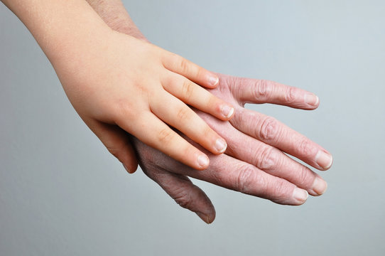Hands of young child and old woman