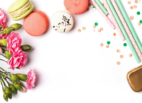 Macarons, paper straws, flowers and confetti on the white backgr