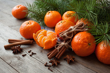  Tangerines with cinnamon, anise and fir branches on a wooden table. Christmas background card with...