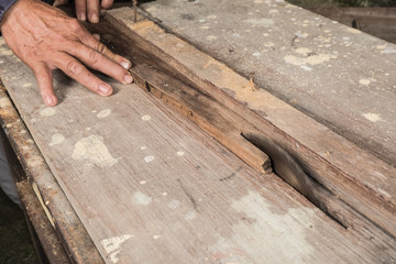 Asian carpenter Is sawing wood, Working hands with tools