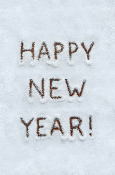 Text HAPPY NEW YEAR written on snow with wood background. Vertical holiday top view postcard.