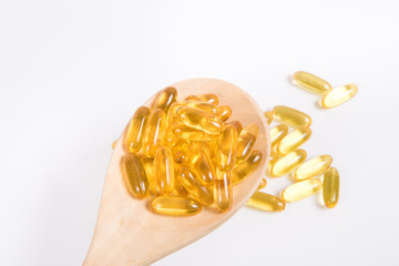 Omega 3 fish oil capsule on wooden spoon