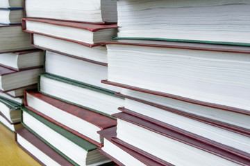 A pile of archival volumes with documents on the table