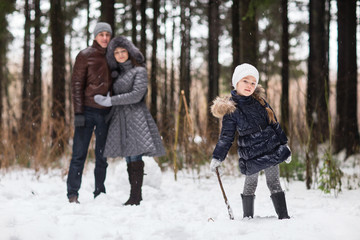Fototapeta na wymiar Happy family walking in a winter park.