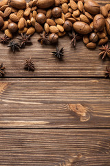 Nuts and star anise on wooden undeground. Top view.