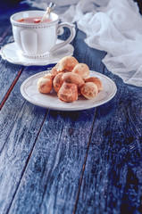 teacup with tea and biscuits on a black table