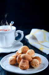 teacup with tea and biscuits on a black table