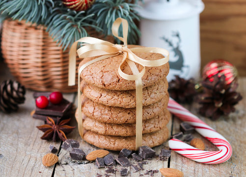 Spiced cookies with almonds. Christmas gifts. Round cookies, tied with ribbon and spruce branch in a basket on the table
