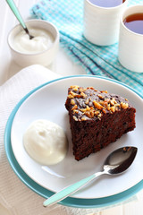 piece of chocolate cake with walnuts served with yogurt