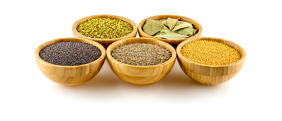 Assorted Indian spices in wooden bowls isolated on white