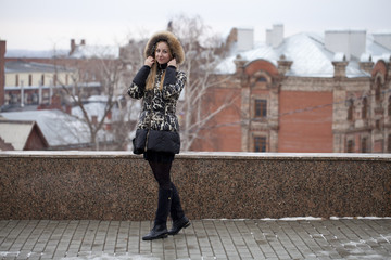 Obraz premium Happy young blonde woman on the background of a winter park