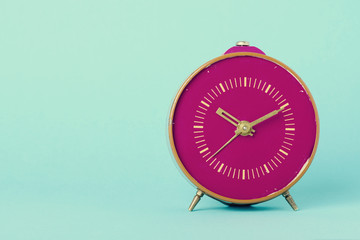 Retro clock on blue background with copy space, vintage toned