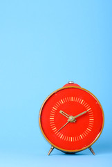 Vintage old red clock on blue background with place for text