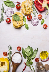 raw pasta with colorful various of organic farm vegetable, wooden spoon, butter and herbs place for text,frame on wooden rustic background top view close up