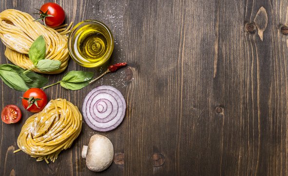 Ingredients for cooking vegetarian pasta on wooden rustic background top view close up border ,with text area