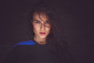 Brunette woman in dark clothes.