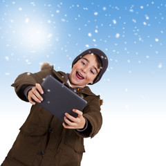 Child with tablet and snowing sky