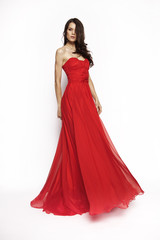 Obraz na płótnie Canvas Brunette model in red dress posing 
