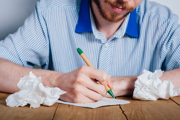 Young man writing on napkin