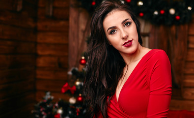 Young woman in red dress at Christmas decorated home