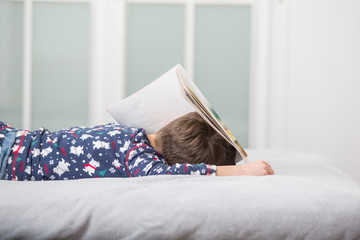 Tired boy sleeping on book
