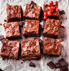  Brownie pieces with nuts decorated with berries  on the white paper.