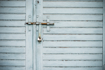 Wooden warehouse door secured with a latch and padlock