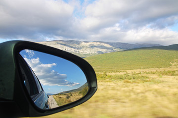 Side mirror view of the scenery during a trip in Croatia.