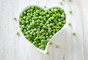 frozem peas on wooden surface