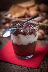 Layered dessert in a glass on a wooden table.