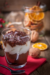 Layered dessert in a glass on a wooden table.