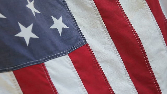 an old fabric American flag in a morning breeze
