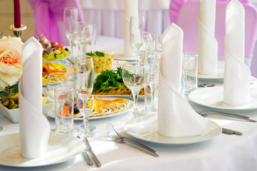 Festive table. Table setting. Festive round table with food.  Starched napkins and Cutlery. Festive meals. The restaurant inside. Service holidays. Design of the hall.