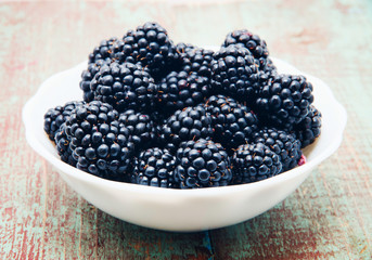 Blackberries in a bowl on wooden table
