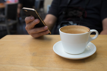 Man check updates on phone while having coffee