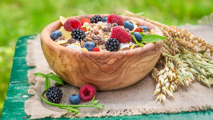 Healthy breakfast with berry fruits and milk in garden