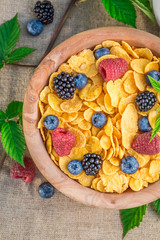 Healthy cornflakes with milk and berry fruits