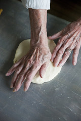 close up of an elderly woman's hands making a pie in the kitchen