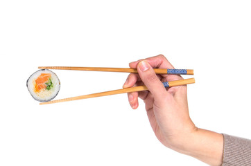 Woman hand holding fresh maki sushi roll with wooden chopsticks,
