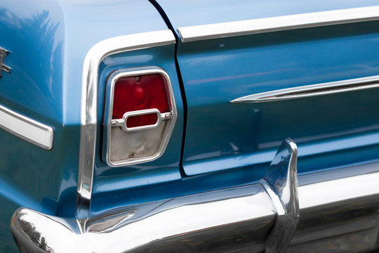 Close-up of right tail light of a blue shiny classic vintage car