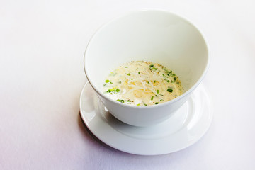 Cream soup in a deep white plate on a white background