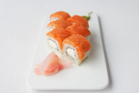 Sushi roll with salmon and philadelphia cheese on white background