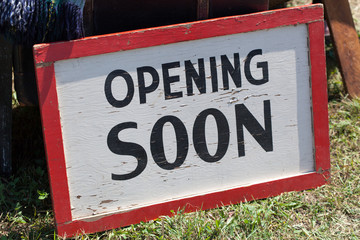 Close-up of opening soon signboard